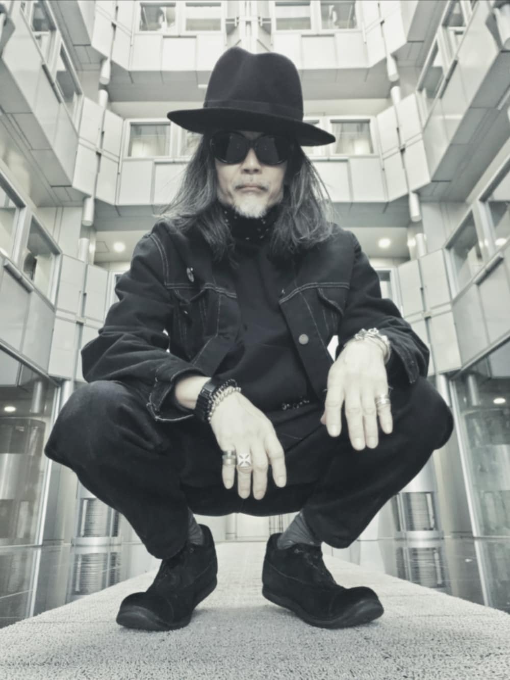 ブラック系のドレスシューズ、ブラック系のデニムパンツ、ブラック系のトートバッグを着用したメンズの春コーディネートの2枚目の写真