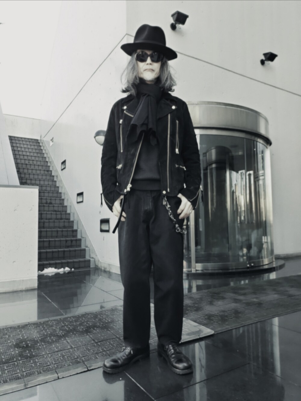 ブラック系のデニムパンツ、ブラック系のニット/セーター、ブラック系のドレスシューズを着用したメンズの冬コーディネートの5枚目の写真