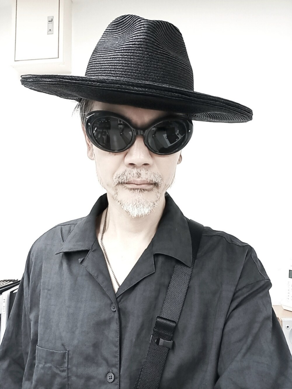 ブルー系のスラックス、ブラック系のドレスシューズ、ブラック系のボディバッグ/ウエストポーチを着用したメンズの夏コーディネートの3枚目の写真