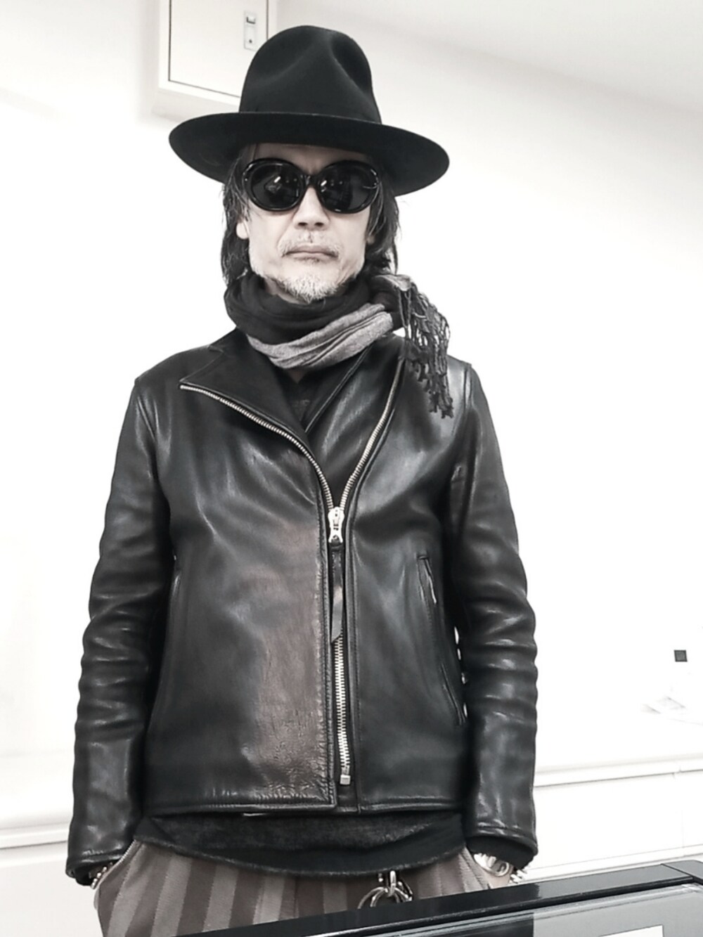 ブラウン系のその他パンツ、ブラック系のライダースジャケット、ブラック系のモカシン/デッキシューズを着用したメンズの冬コーディネートの2枚目の写真