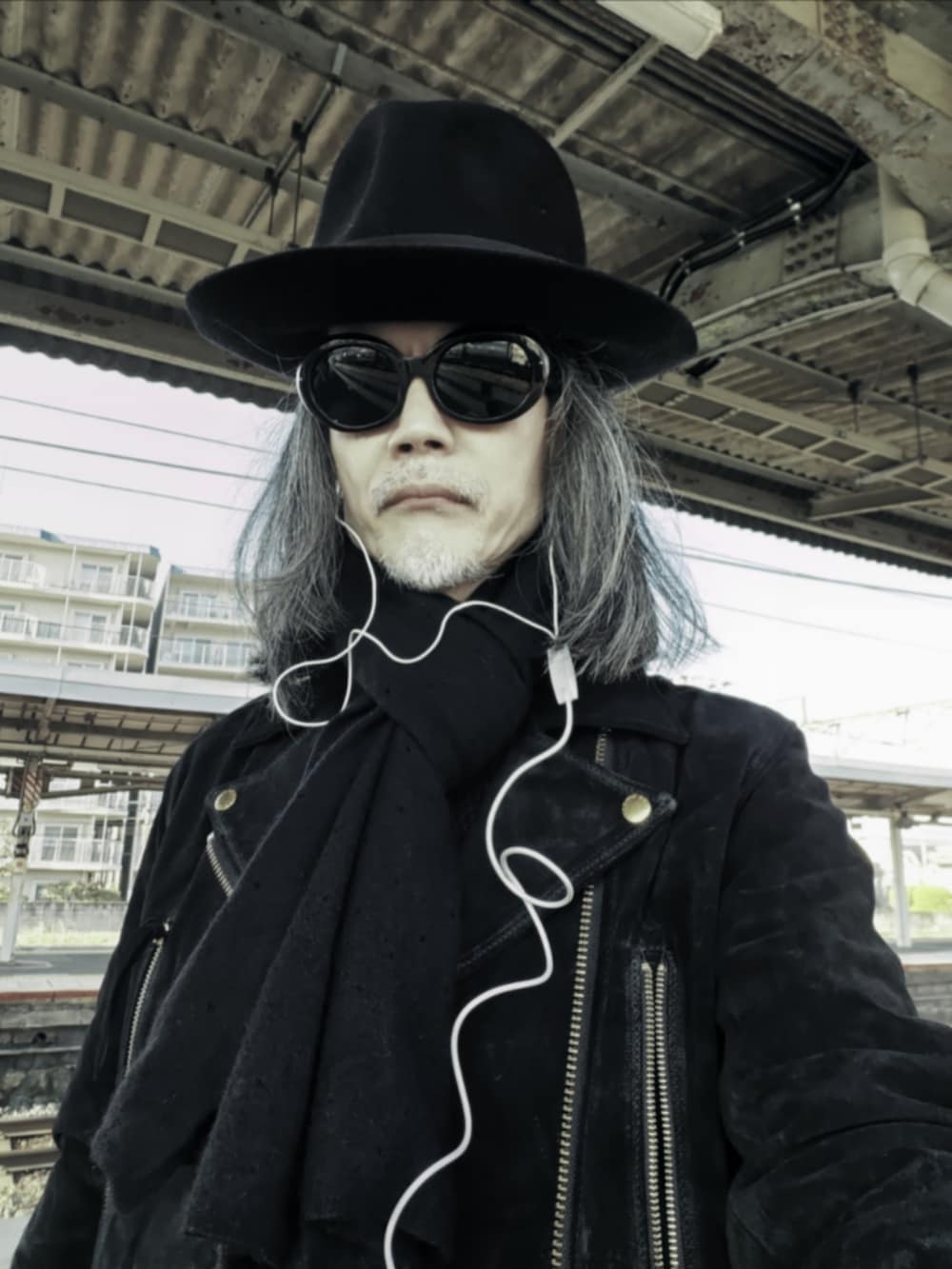 ブラック系のデニムパンツ、ブラック系のニット/セーター、ブラック系のドレスシューズを着用したメンズの冬コーディネートの4枚目の写真