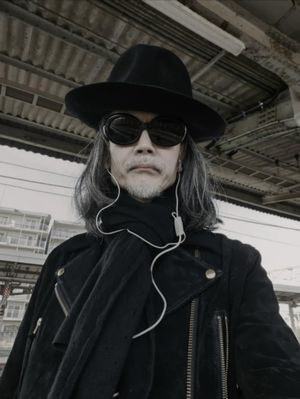 ブラック系のデニムパンツ、ブラック系のドレスシューズ、ブラック系のライダースジャケットを着用したメンズの冬コーディネートの4枚目の写真