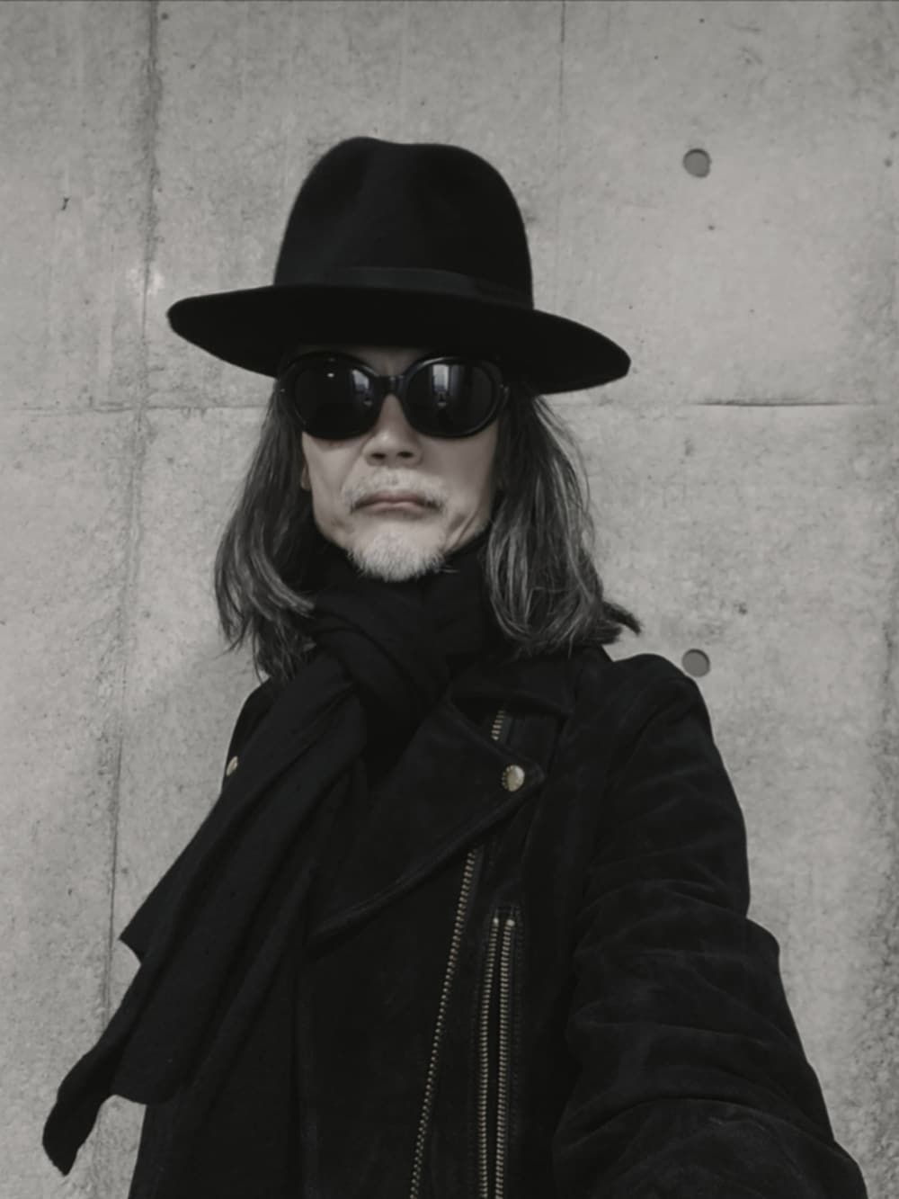 ブラック系のデニムパンツ、ブラック系のドレスシューズ、ブラック系のライダースジャケットを着用したメンズの冬コーディネートの5枚目の写真