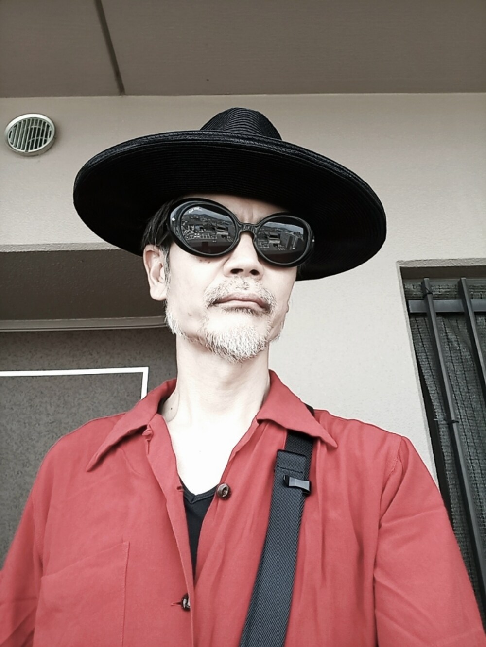 レッド系のシャツ/ブラウス、グレー系のチノパンツ、ホワイト系のその他シューズを着用したメンズの夏コーディネートの2枚目の写真