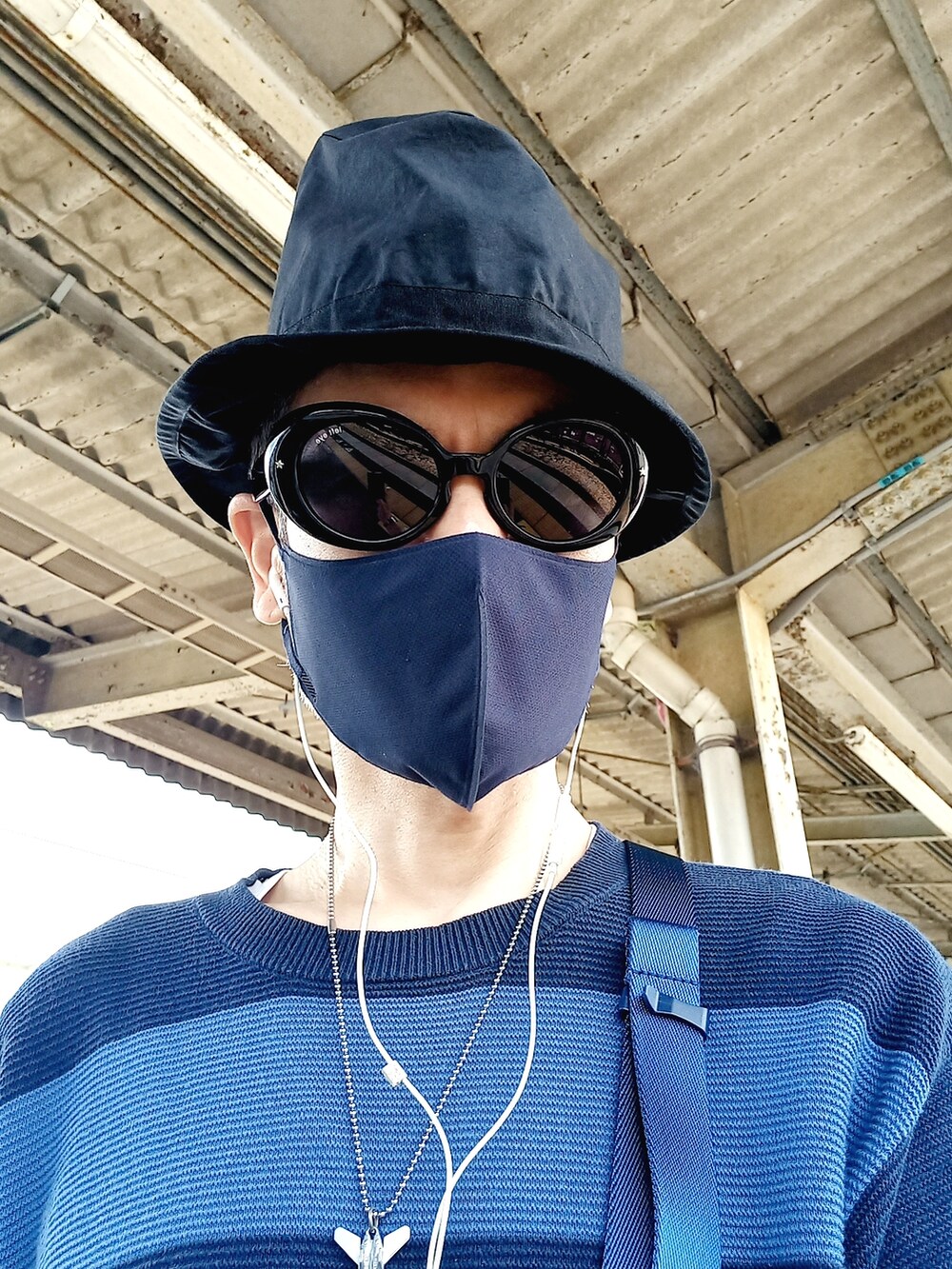 ブルー系のボディバッグ/ウエストポーチ、ブルー系のデニムパンツ、ホワイト系のスニーカーを着用したメンズの秋コーディネートの3枚目の写真