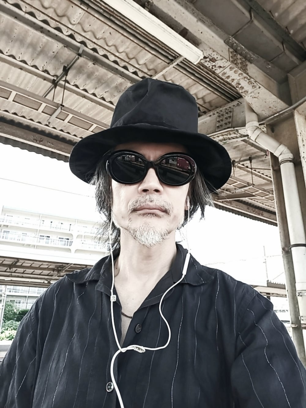 ブラック系のデニムパンツ、グレー系のシャツ/ブラウス、レッド系のブーツを着用したメンズの夏コーディネートの3枚目の写真