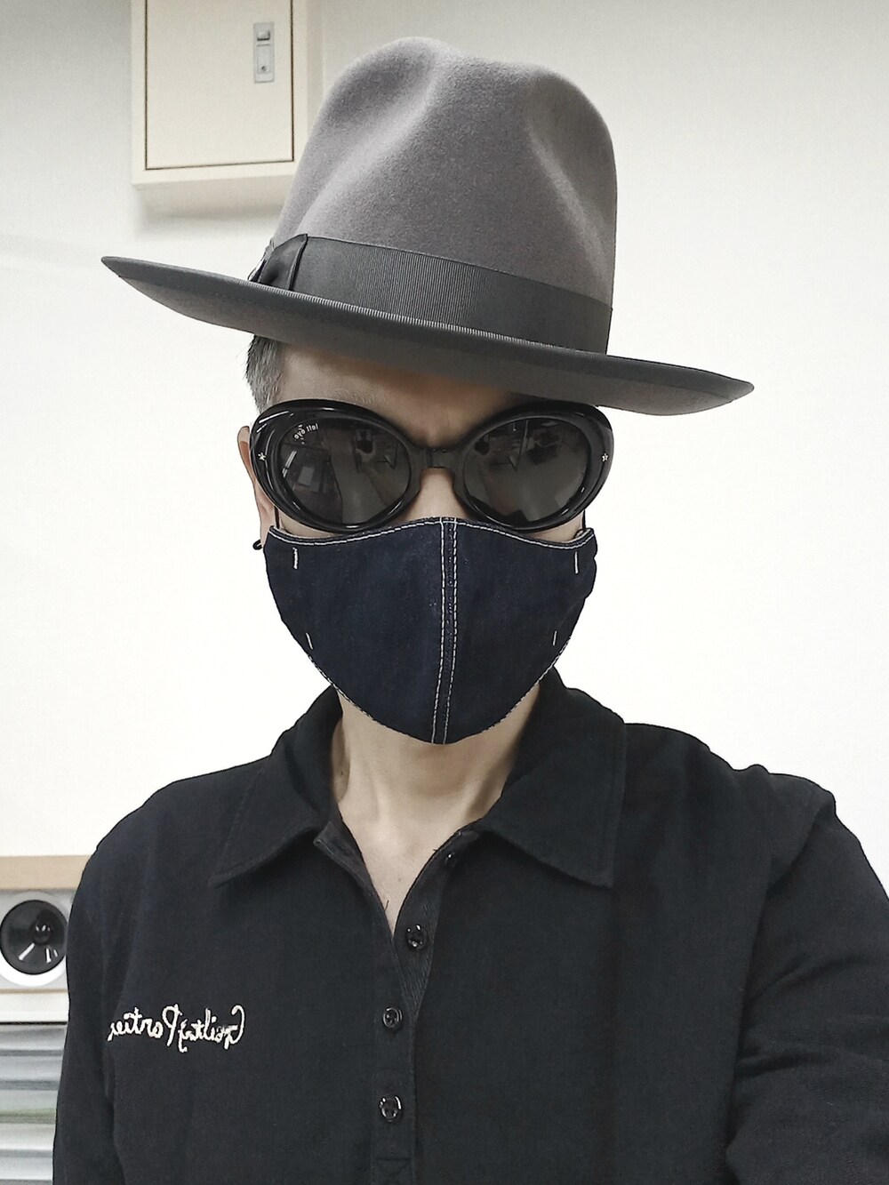 ブラック系のスニーカー、ブラック系のチノパンツ、ブラック系のポロシャツを着用したメンズの春コーディネートの4枚目の写真