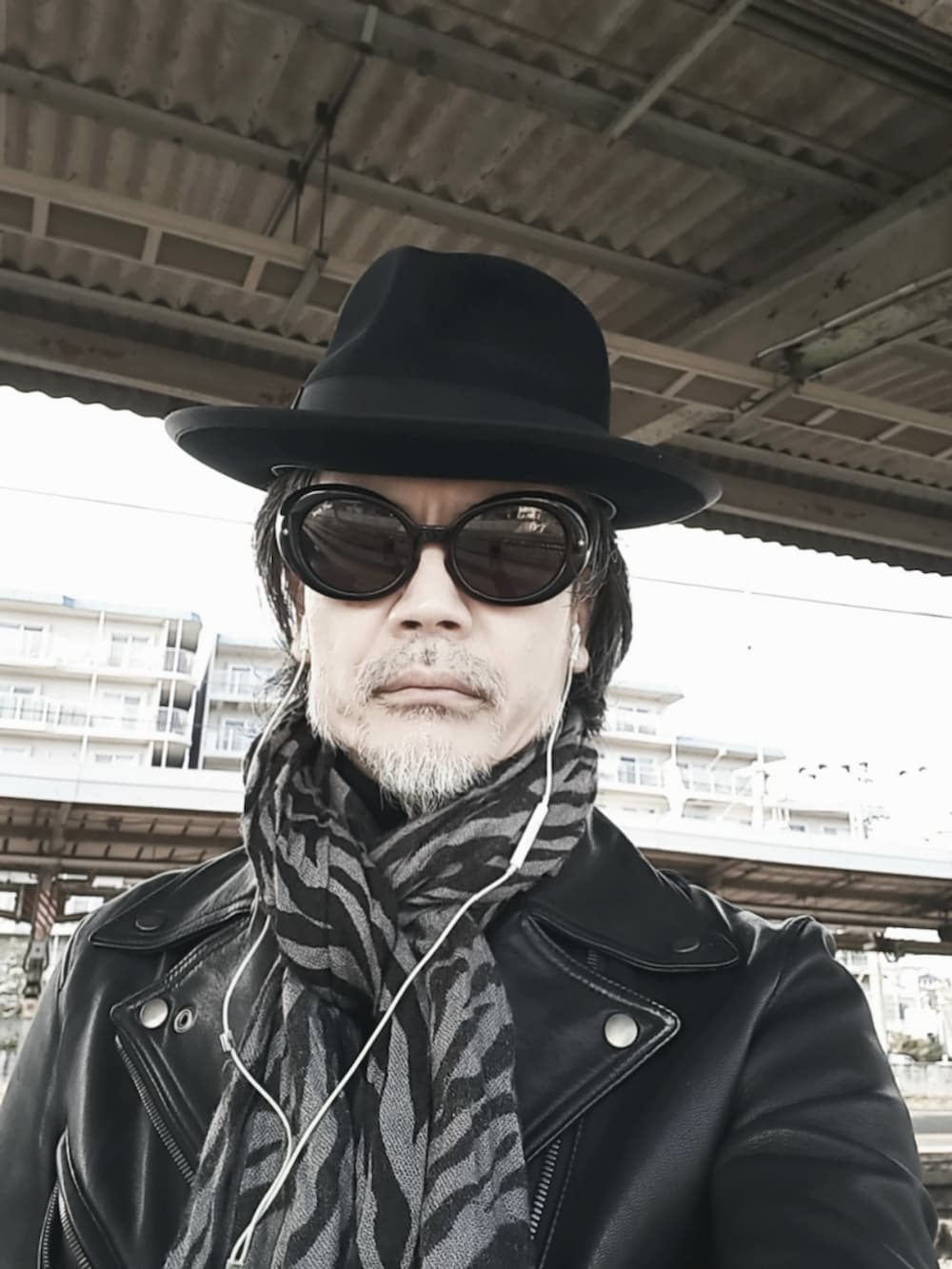 ブラック系のデニムパンツ、ブラック系のライダースジャケット、ブラック系のドレスシューズを着用したメンズの冬コーディネートの4枚目の写真
