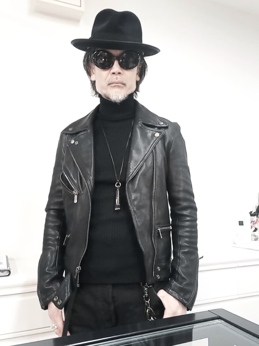ブラック系のデニムパンツ、ブラック系のライダースジャケット、ブラック系のドレスシューズを着用したメンズの冬コーディネートの3枚目の写真