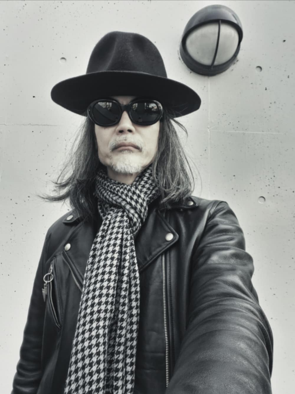 ブラック系のデニムパンツ、ブラック系のスニーカー、ブラック系のライダースジャケットを着用したメンズの春コーディネートの5枚目の写真