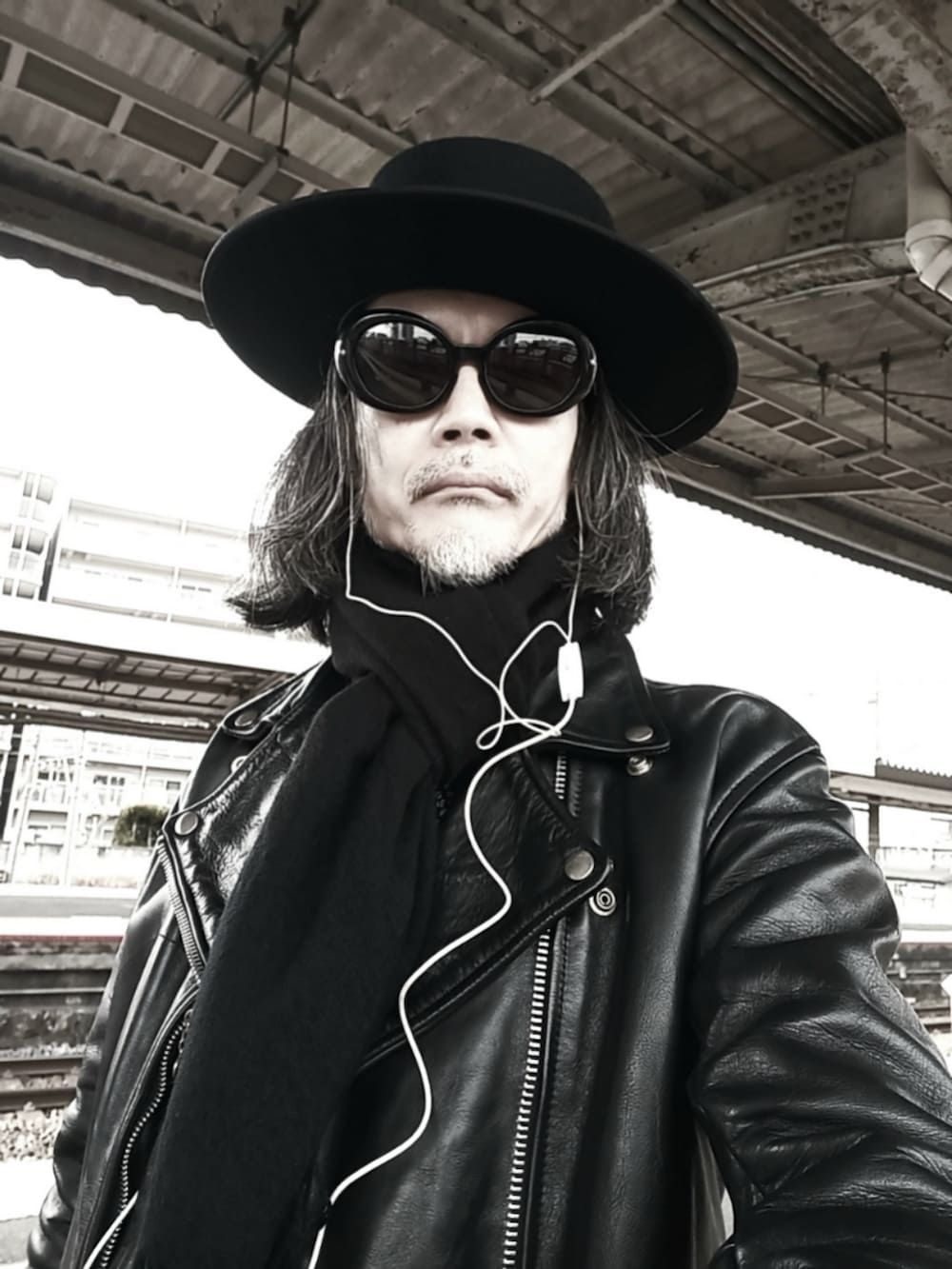 ブラック系のデニムパンツ、ブラック系のドレスシューズ、ブラック系のライダースジャケットを着用したメンズの春コーディネートの4枚目の写真