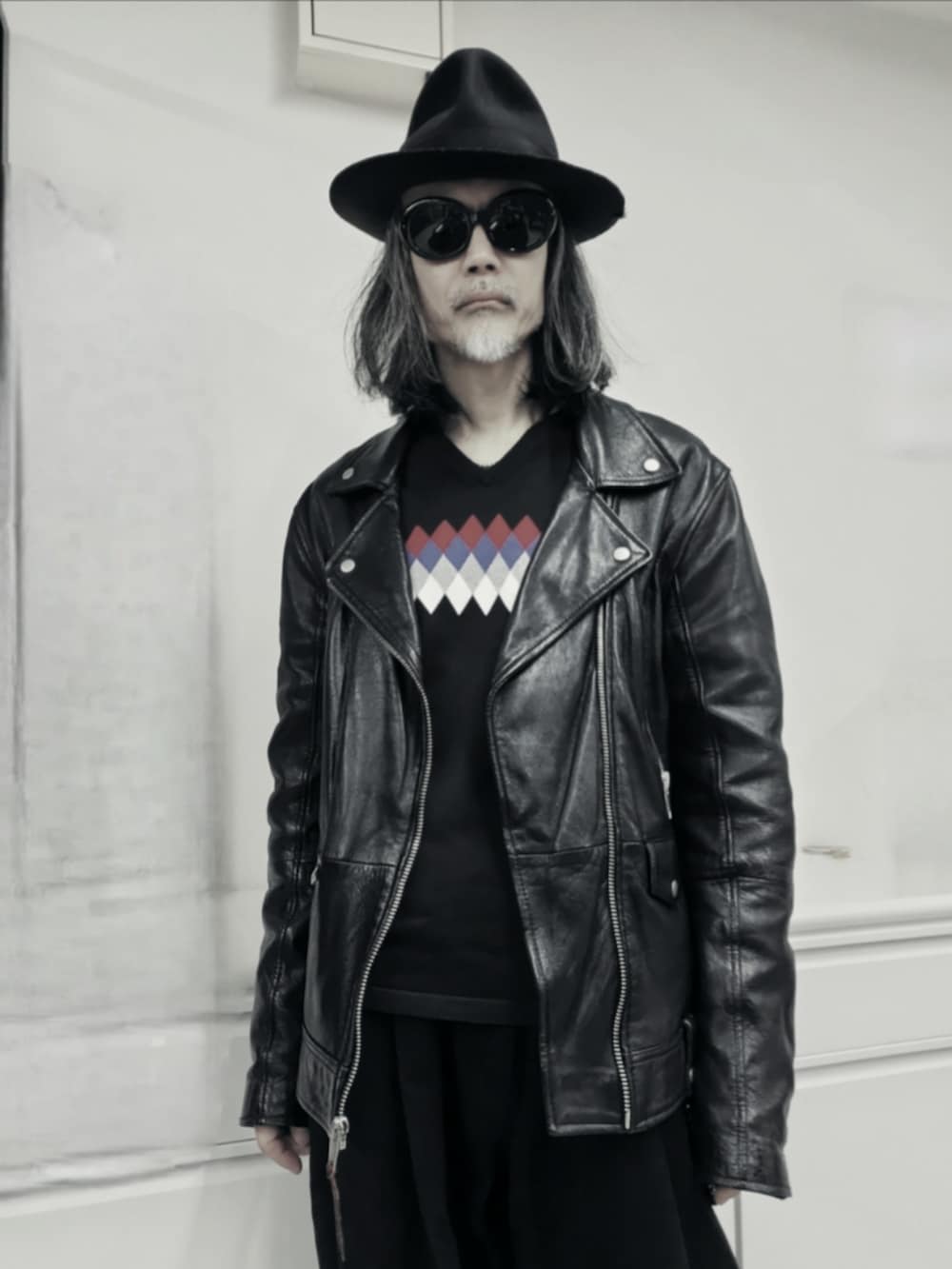 ブラック系のライダースジャケット、ブラック系のデニムパンツ、ブラック系のニット/セーターを着用したメンズの秋コーディネートの2枚目の写真