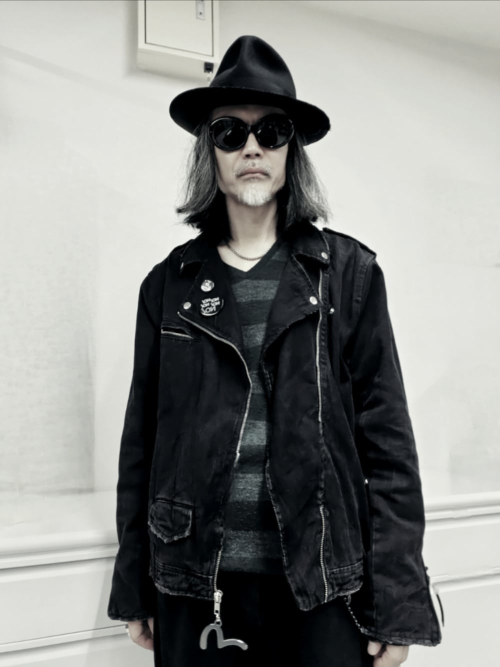 ブラック系のライダースジャケット、ブラック系のデニムパンツ、ブラック系のドレスシューズを着用したメンズの秋コーディネートの2枚目の写真