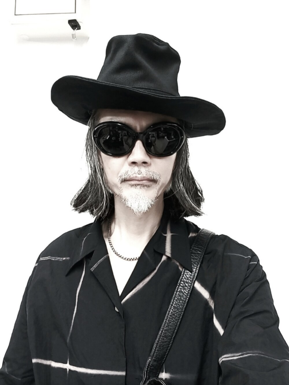 ブラック系のシャツ/ブラウス、グレー系のチノパンツ、ブラック系のドレスシューズを着用したメンズの夏コーディネートの3枚目の写真