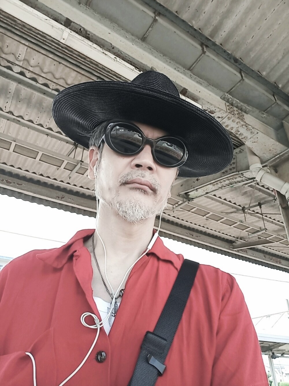 レッド系のシャツ/ブラウス、グレー系のチノパンツ、ホワイト系のその他シューズを着用したメンズの夏コーディネートの3枚目の写真