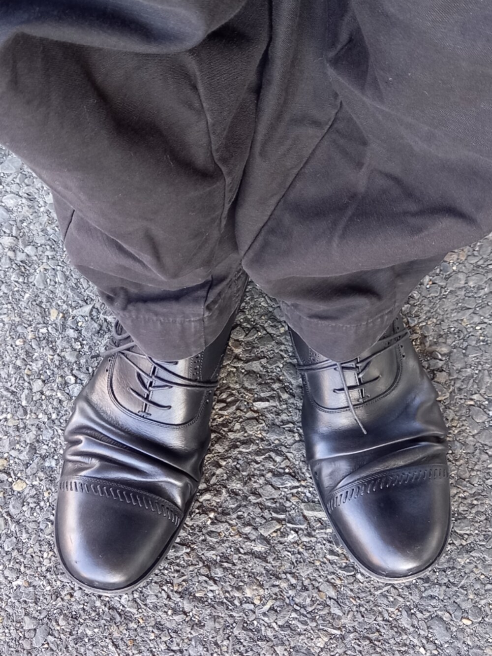 ブラック系のカーゴパンツ、ブラック系のライダースジャケット、ブラック系のドレスシューズを着用したメンズの冬コーディネートの5枚目の写真