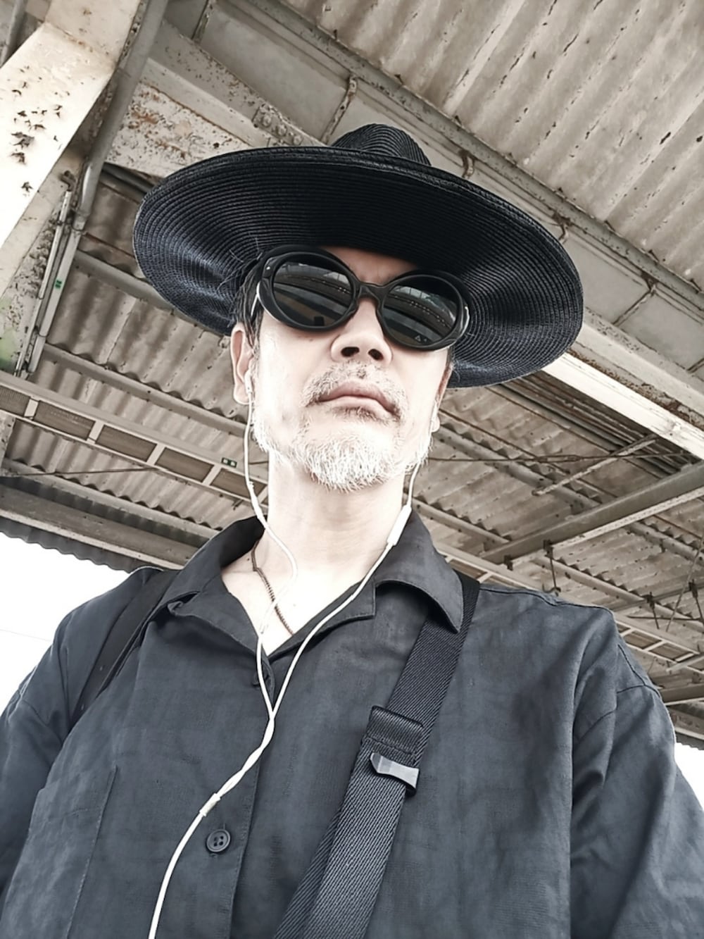 ブルー系のスラックス、ブラック系のドレスシューズ、ブラック系のボディバッグ/ウエストポーチを着用したメンズの夏コーディネートの4枚目の写真