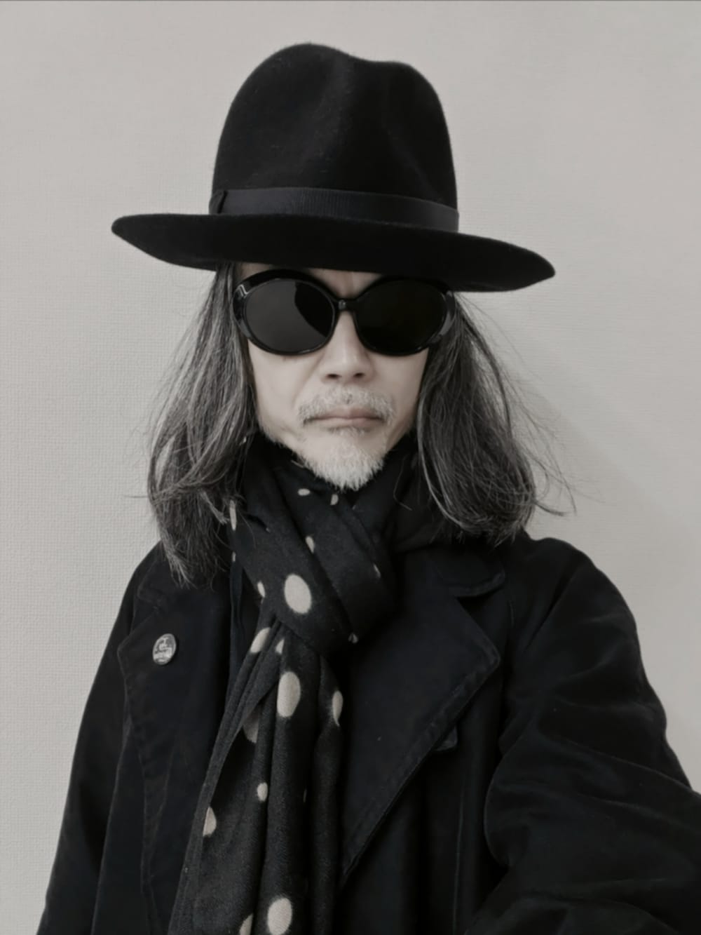 ブラック系のチェスターコート、ブラック系のデニムパンツ、ブラック系のドレスシューズを着用したメンズの冬コーディネートの5枚目の写真