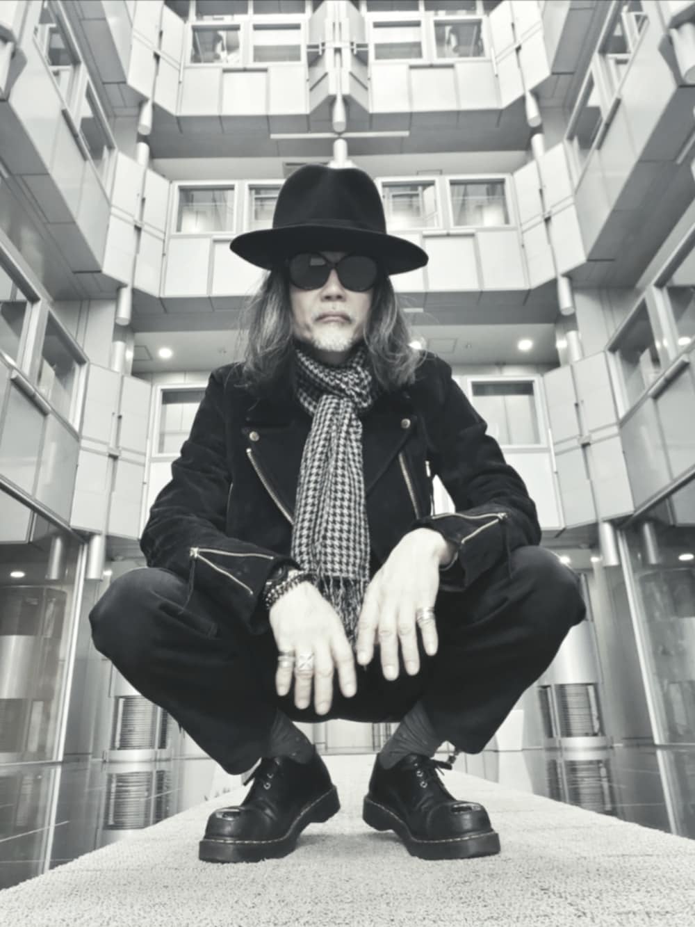 ブラック系のデニムパンツ、ブラック系のドレスシューズ、ブラック系のライダースジャケットを着用したメンズの春コーディネートの3枚目の写真