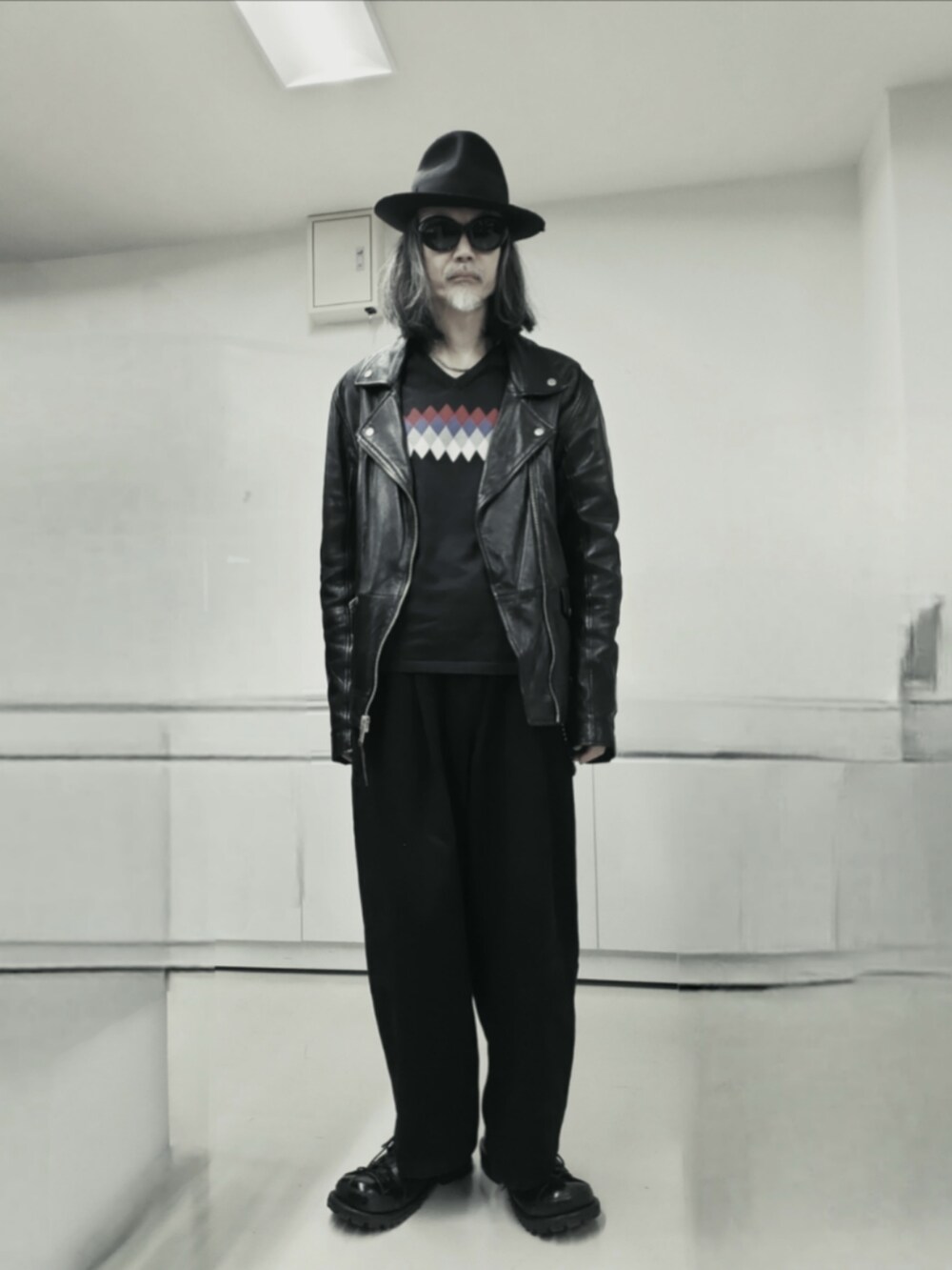 ブラック系のライダースジャケット、ブラック系のデニムパンツ、ブラック系のニット/セーターを着用したメンズの秋コーディネートの5枚目の写真