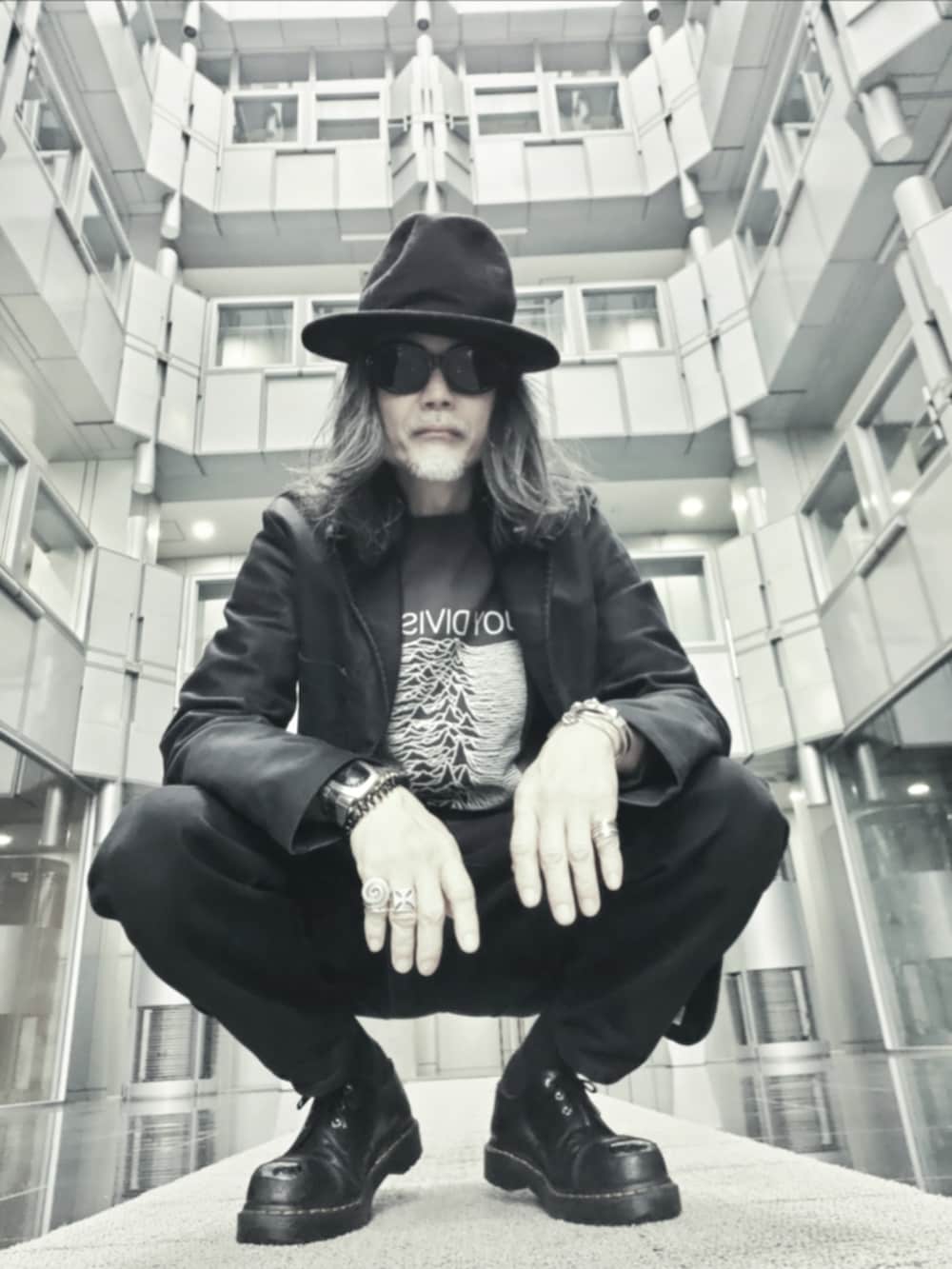 ブラック系のテーラードジャケット、ブラック系のデニムパンツ、ブラック系のドレスシューズを着用したメンズの春コーディネートの2枚目の写真