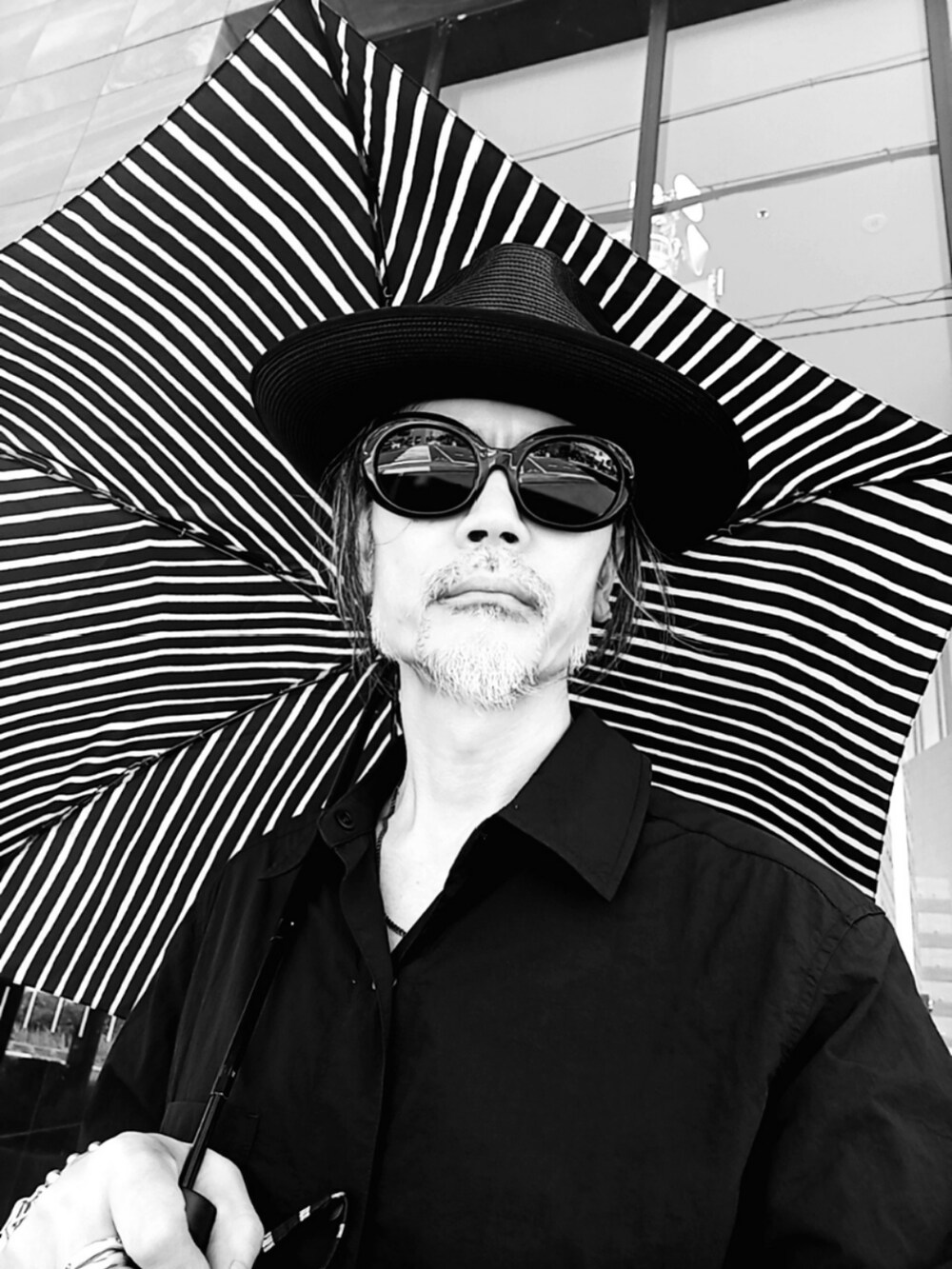 ブラック系のシャツ/ブラウス、ブルー系のデニムパンツ、ブラック系のスニーカーを着用したメンズの秋コーディネートの4枚目の写真