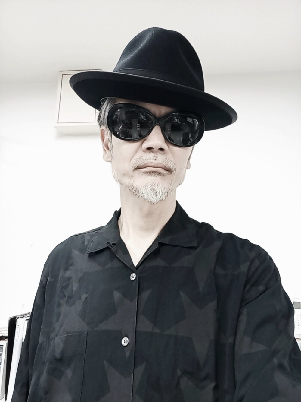ブラック系のシャツ/ブラウス、ブラック系のチノパンツ、ブラック系のドレスシューズを着用したメンズの春コーディネートの3枚目の写真