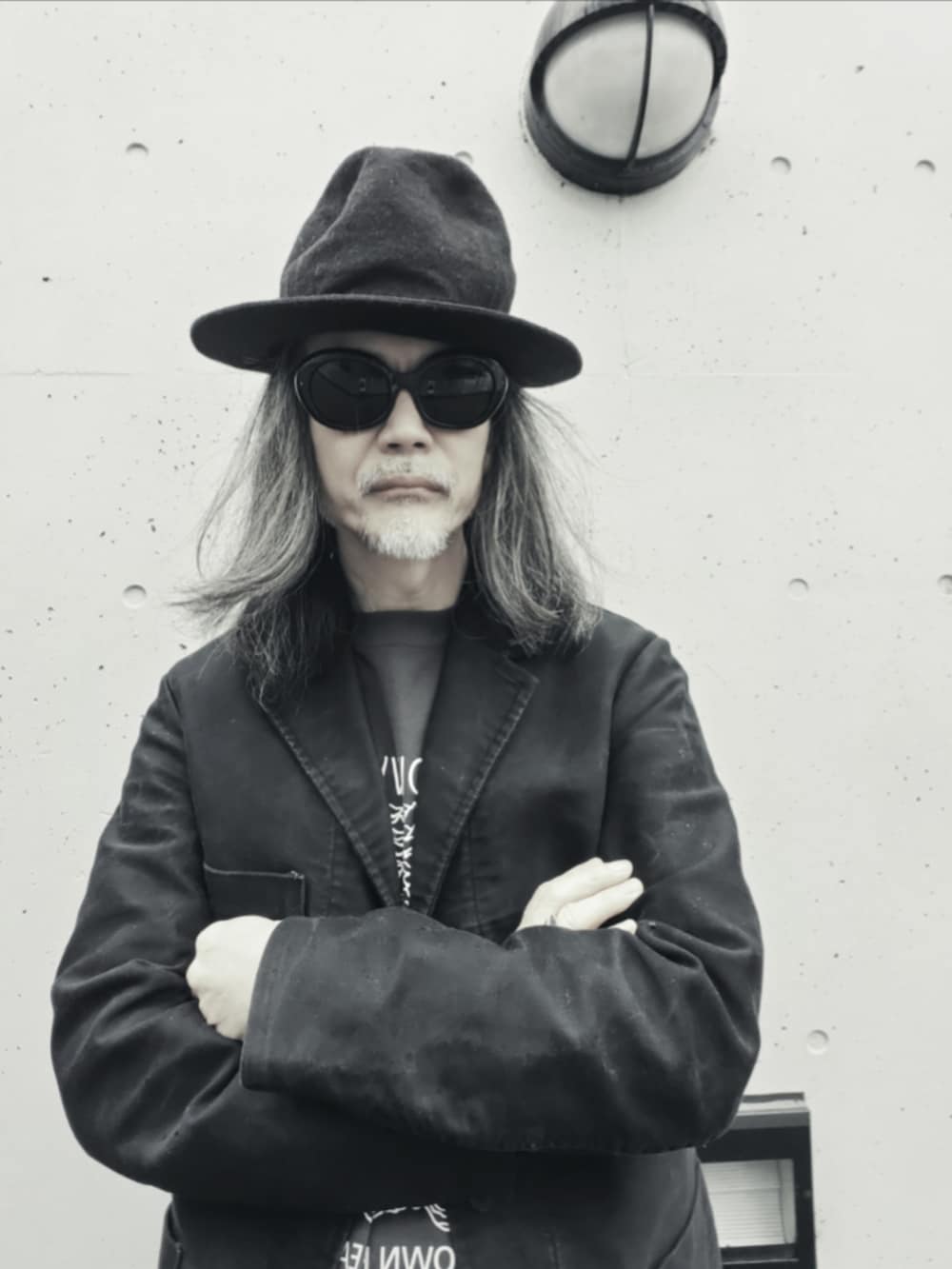 ブラック系のテーラードジャケット、ブラック系のデニムパンツ、ブラック系のドレスシューズを着用したメンズの春コーディネートの5枚目の写真