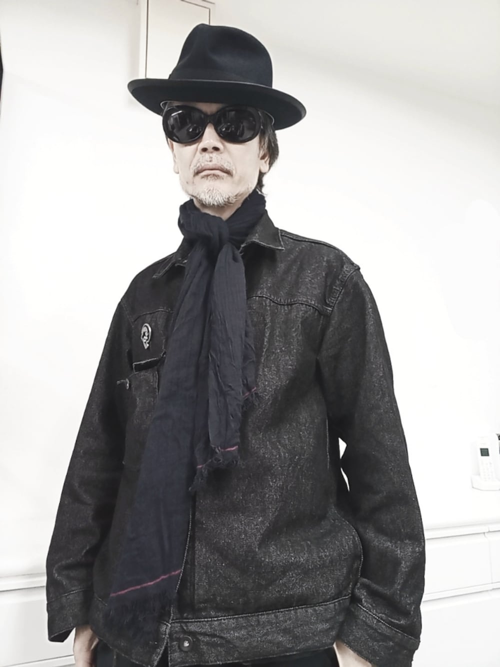 ブルー系のカーゴパンツ、ブラック系のデニムジャケット、ブラック系のブーツを着用したメンズの秋コーディネートの2枚目の写真