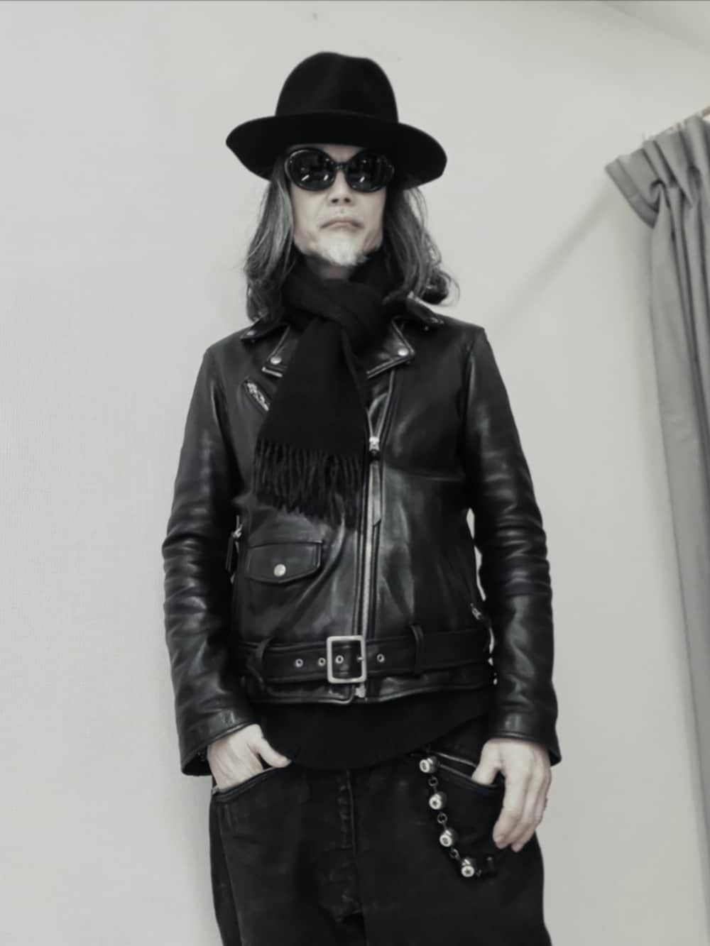 ブラック系のデニムパンツ、ブラック系のライダースジャケット、ブラック系のトートバッグを着用したメンズの冬コーディネートの3枚目の写真