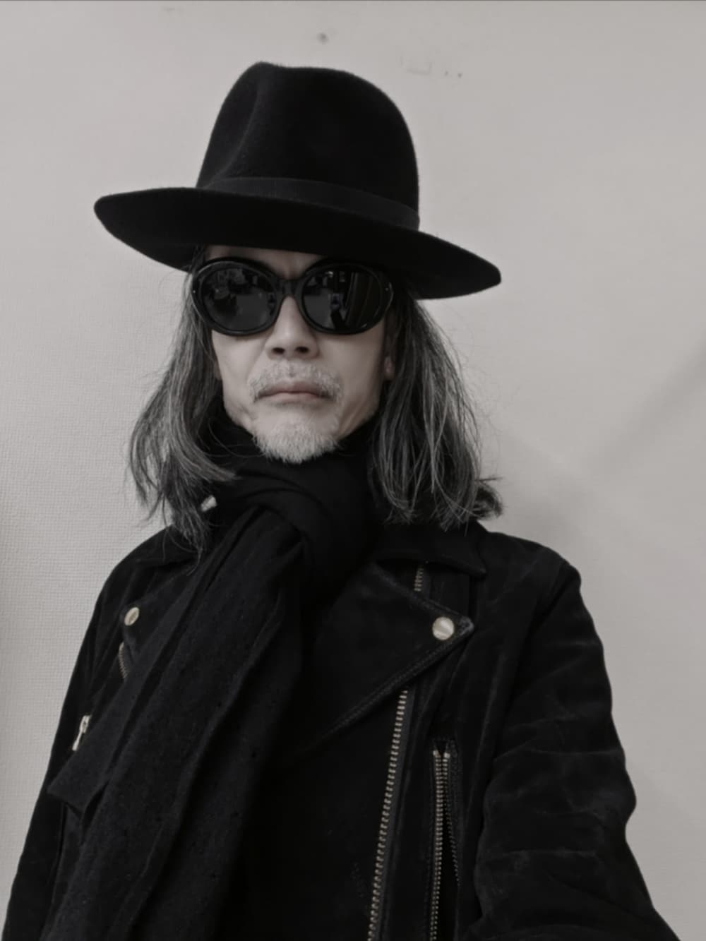 ブラック系のデニムパンツ、ブラック系のドレスシューズ、ブラック系のライダースジャケットを着用したメンズの冬コーディネートの3枚目の写真