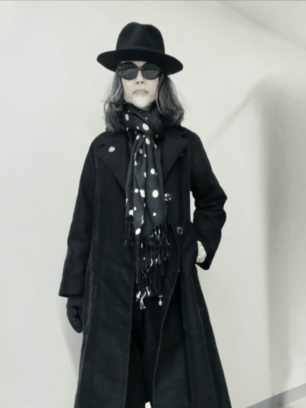 ブラック系のチェスターコート、ブラック系のデニムパンツ、ブラック系のドレスシューズを着用したメンズの冬コーディネートの3枚目の写真