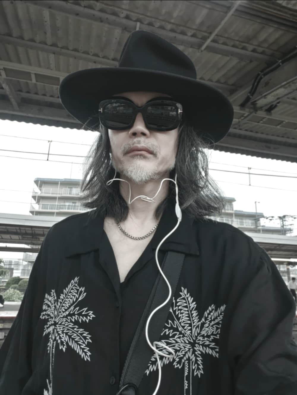 ブラック系のシャツ/ブラウス、ブラック系のカーゴパンツ、ブラック系のモカシン/デッキシューズを着用したメンズの夏コーディネートの2枚目の写真