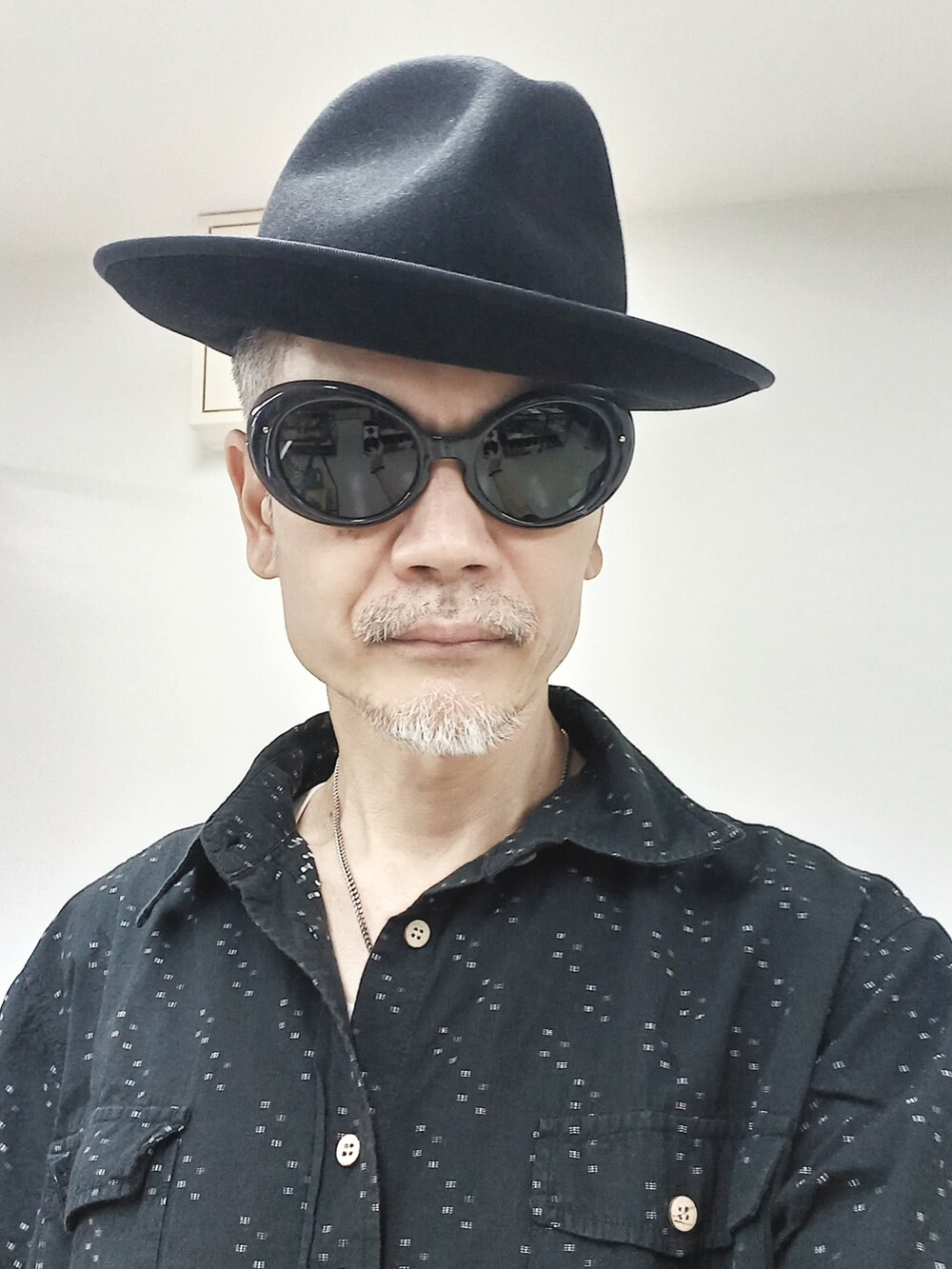 ブルー系のデニムパンツ、ブラック系のシャツ/ブラウス、ブラック系のブーツを着用したメンズの夏コーディネートの3枚目の写真