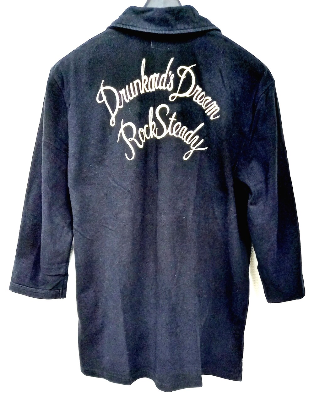 ブラック系のスニーカー、ブラック系のチノパンツ、ブラック系のポロシャツを着用したメンズの春コーディネートの5枚目の写真