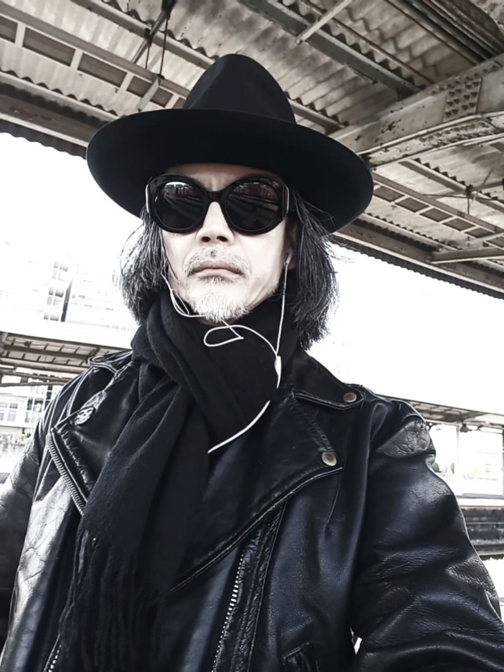 ブラック系のライダースジャケット、ブルー系のデニムパンツ、ブラック系のドレスシューズを着用したメンズの春コーディネートの4枚目の写真