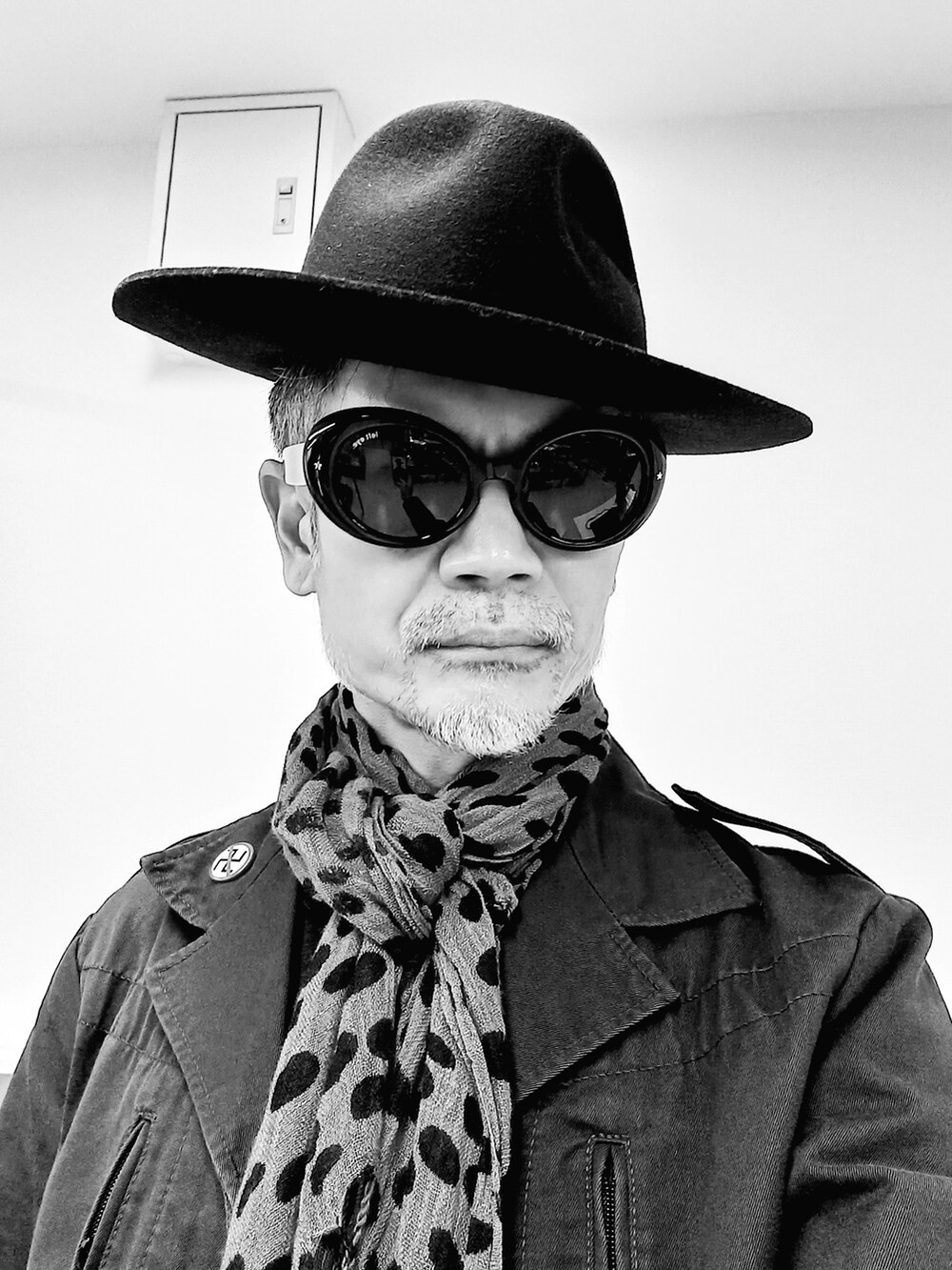 ブラック系のブーツ、ブラック系のチノパンツ、ブラック系のミリタリージャケットを着用したメンズの春コーディネートの2枚目の写真