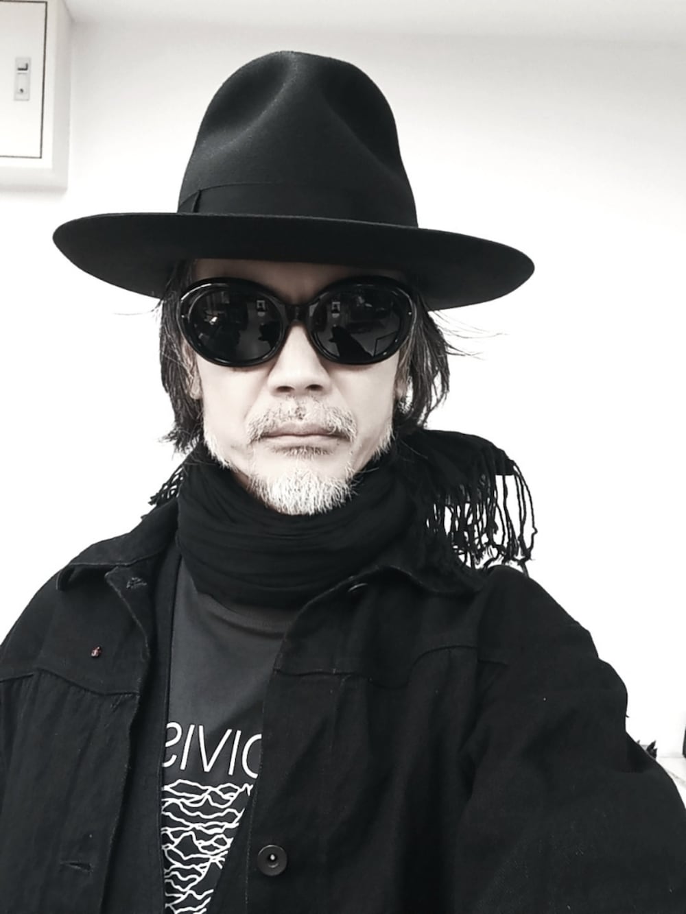 ブラック系のデニムジャケット、ブラック系のベスト、グレー系のTシャツ/カットソーを着用したメンズの春コーディネートの4枚目の写真