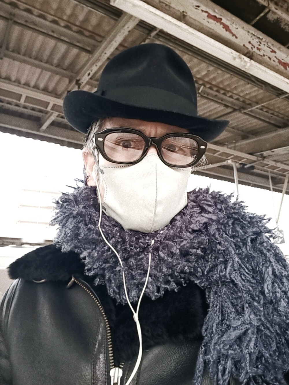 ブラック系のムートンコート、ブラック系のカーゴパンツ、ブラック系のブーツを着用したメンズの冬コーディネートの5枚目の写真