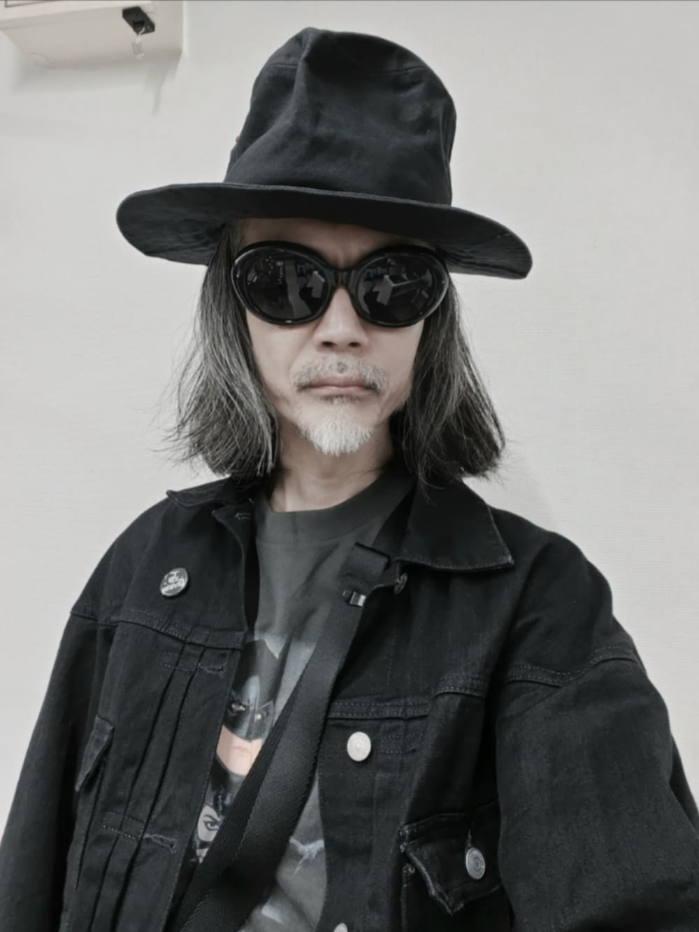 ブラック系のチノパンツ、グレー系のTシャツ/カットソー、ブラック系のデニムジャケットを着用したメンズの秋コーディネートの3枚目の写真