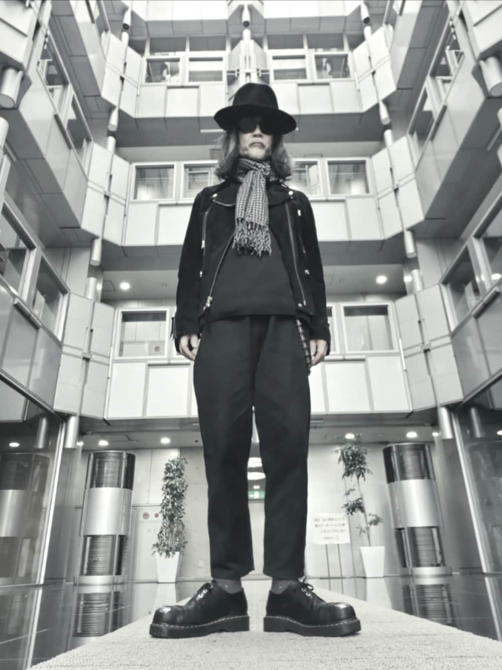 ブラック系のデニムパンツ、ブラック系のドレスシューズ、ブラック系のライダースジャケットを着用したメンズの春コーディネートの2枚目の写真