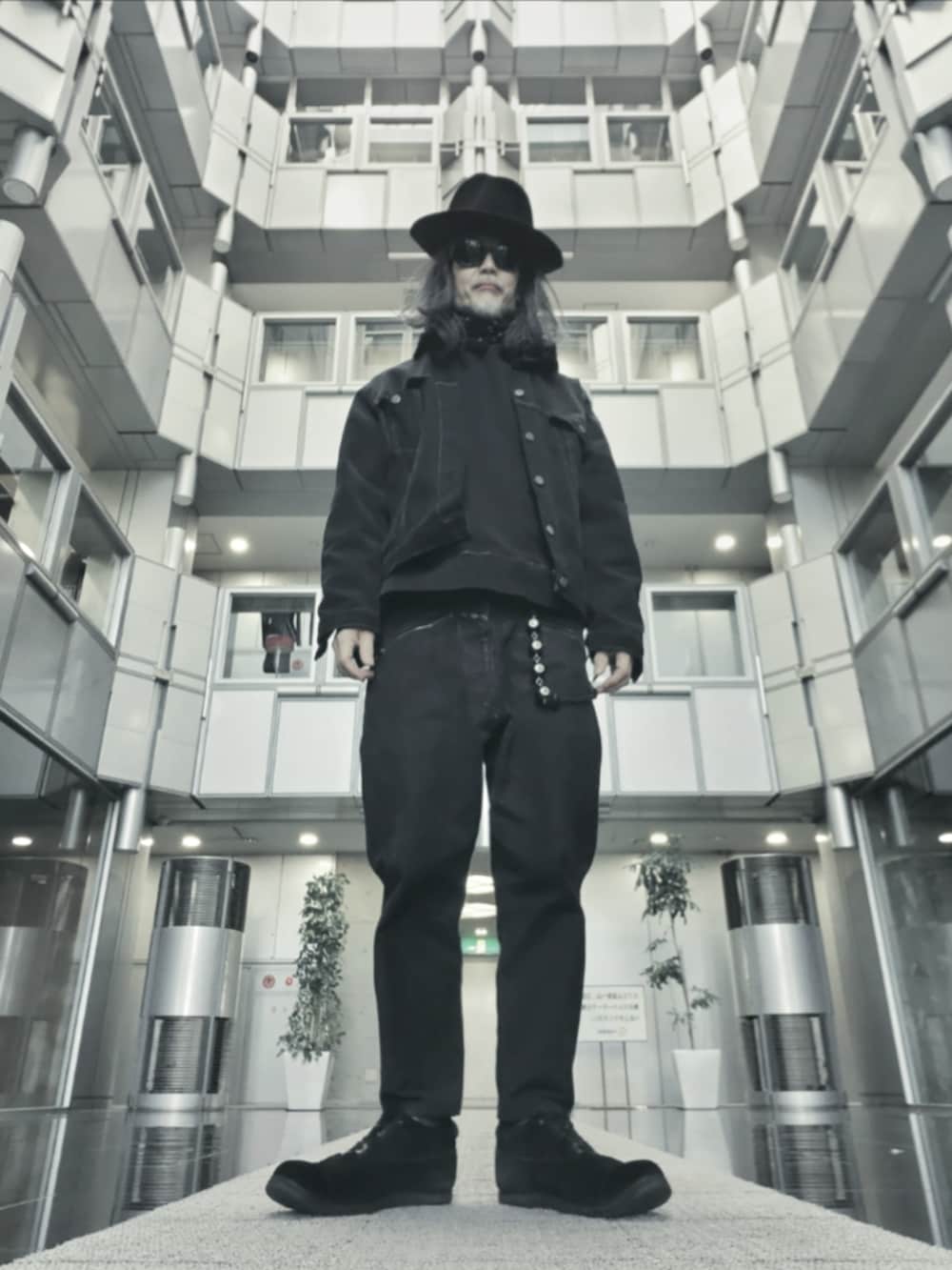 ブラック系のドレスシューズ、ブラック系のデニムパンツ、ブラック系のトートバッグを着用したメンズの春コーディネートの3枚目の写真