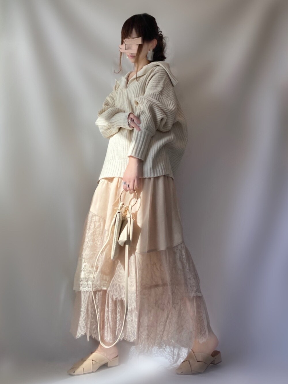 ホワイト系のショルダーバッグ、ホワイト系のニット/セーター、ベージュ系のスカートを着用したレディースの秋コーディネートの3枚目の写真