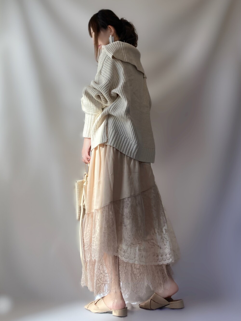 ホワイト系のショルダーバッグ、ホワイト系のニット/セーター、ベージュ系のスカートを着用したレディースの秋コーディネートの2枚目の写真