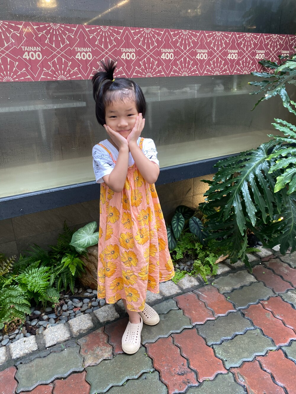 オレンジ系のワンピース、ベージュ系のスリッポンを着用したレディースの秋コーディネートの2枚目の写真