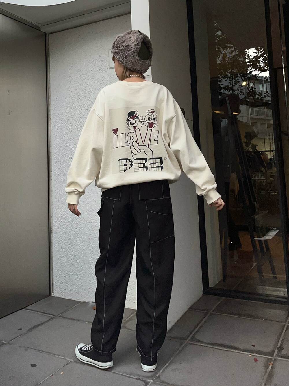 ブラック系のパンツ、ホワイト系のスウェット、ブラック系のスニーカーを着用したレディースの秋コーディネートの2枚目の写真