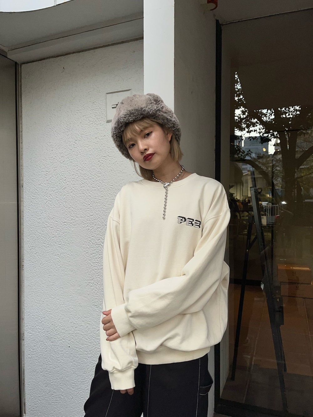 ブラック系のパンツ、ホワイト系のスウェット、ブラック系のスニーカーを着用したレディースの秋コーディネートの3枚目の写真