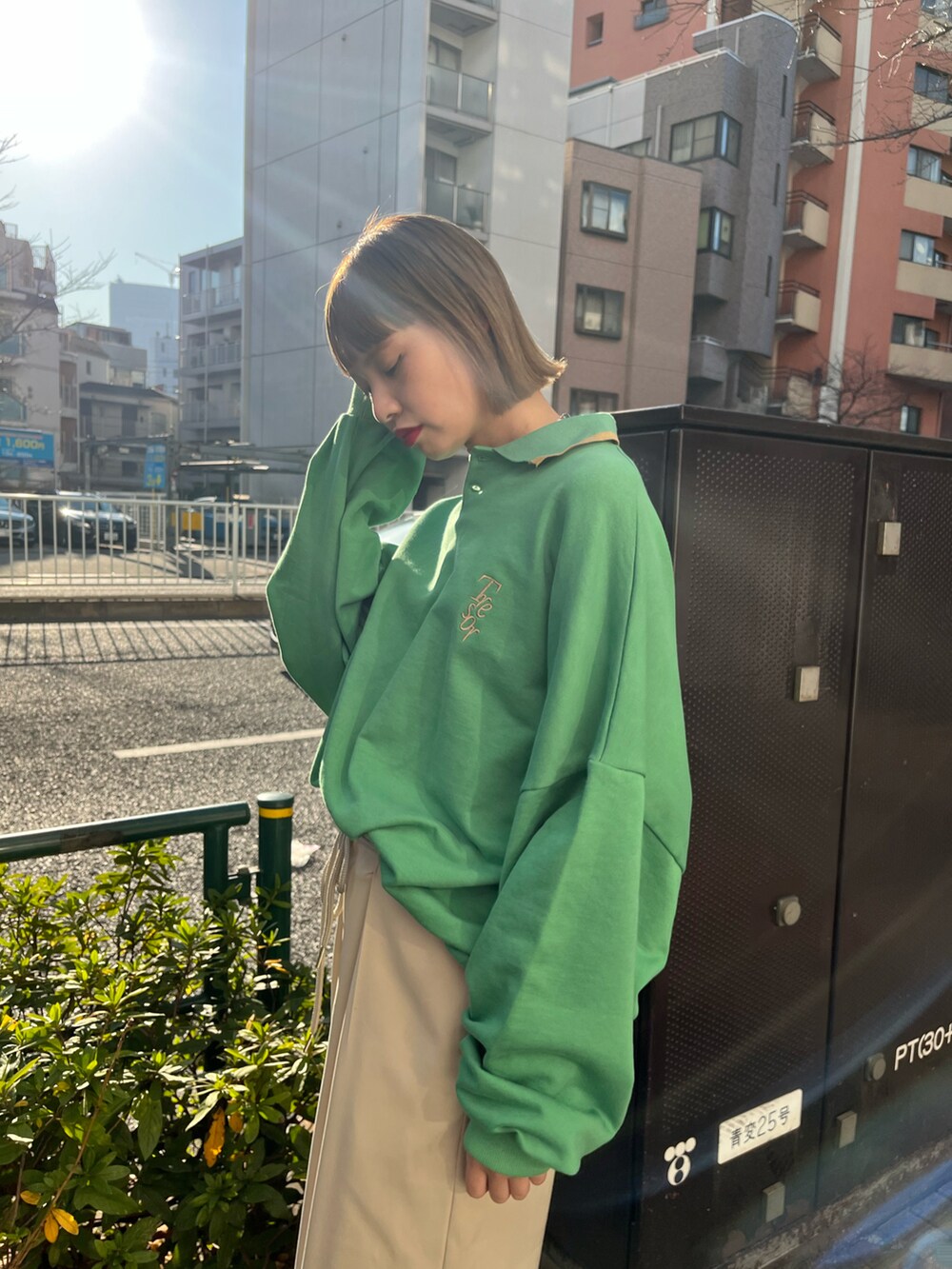 グリーン系のスウェット、ホワイト系のスラックス、ブラック系のスニーカーを着用したレディースの冬コーディネートの2枚目の写真