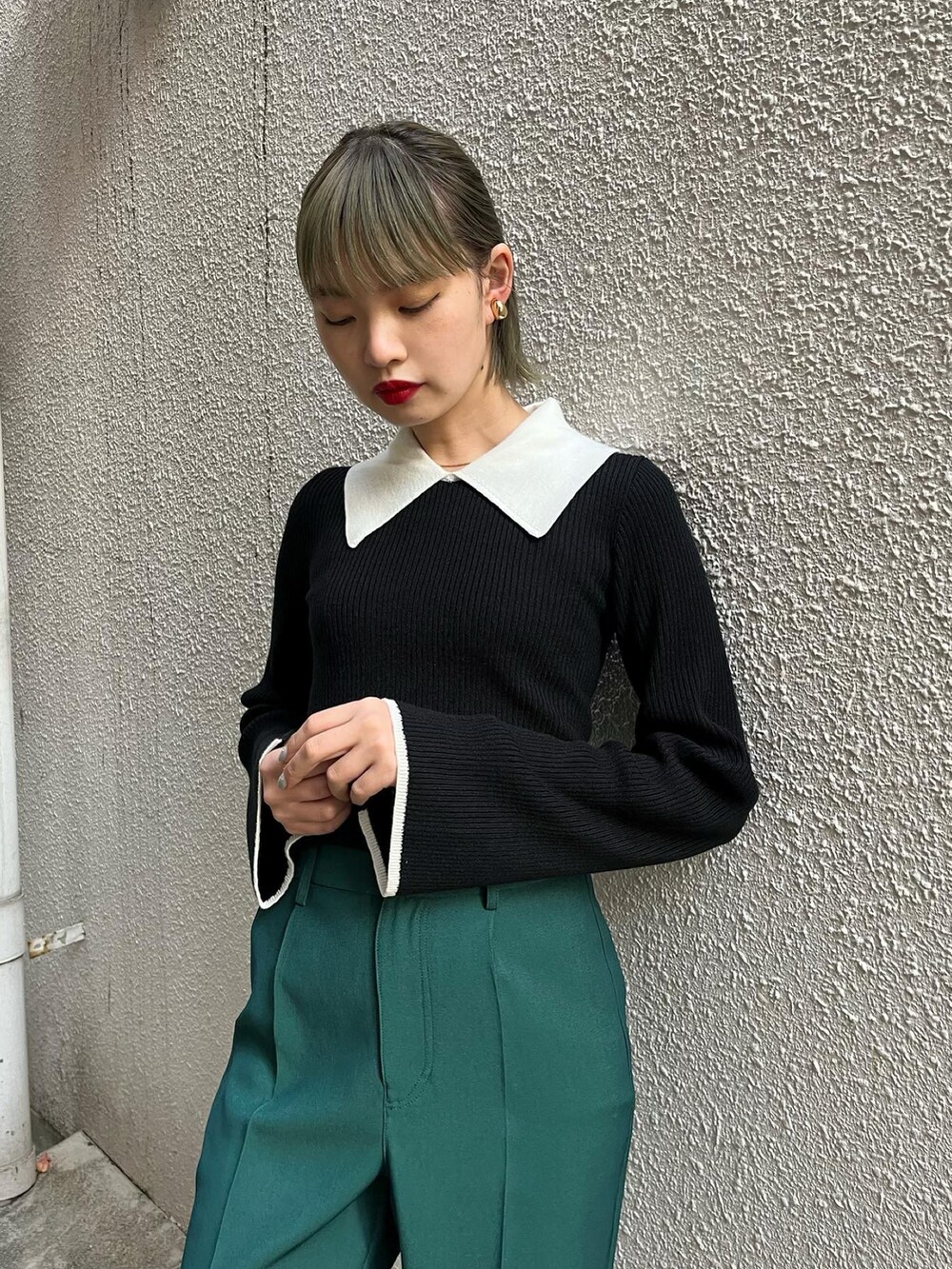 グリーン系のスラックス、ブラック系のニット/セーターを着用したレディースの秋コーディネートの2枚目の写真