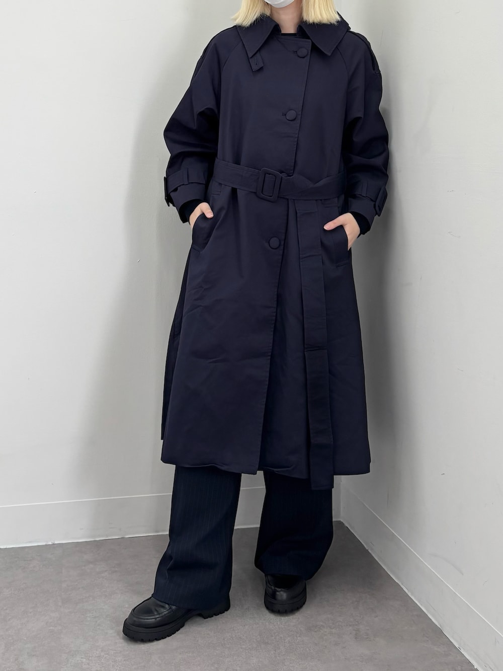 ブルー系のトレンチコートを着用したレディースの冬コーディネートの2枚目の写真